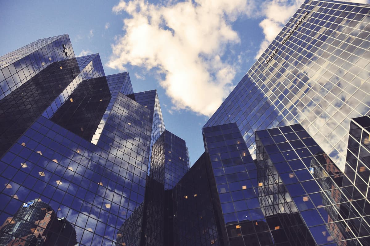 Modern glass skyscrapers reflecting the sky, symbolizing global finance and corporate infrastructure.