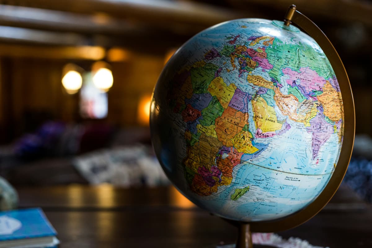 A brightly colored globe on a table in a cozy indoor setting, emphasizing geography and global perspective.